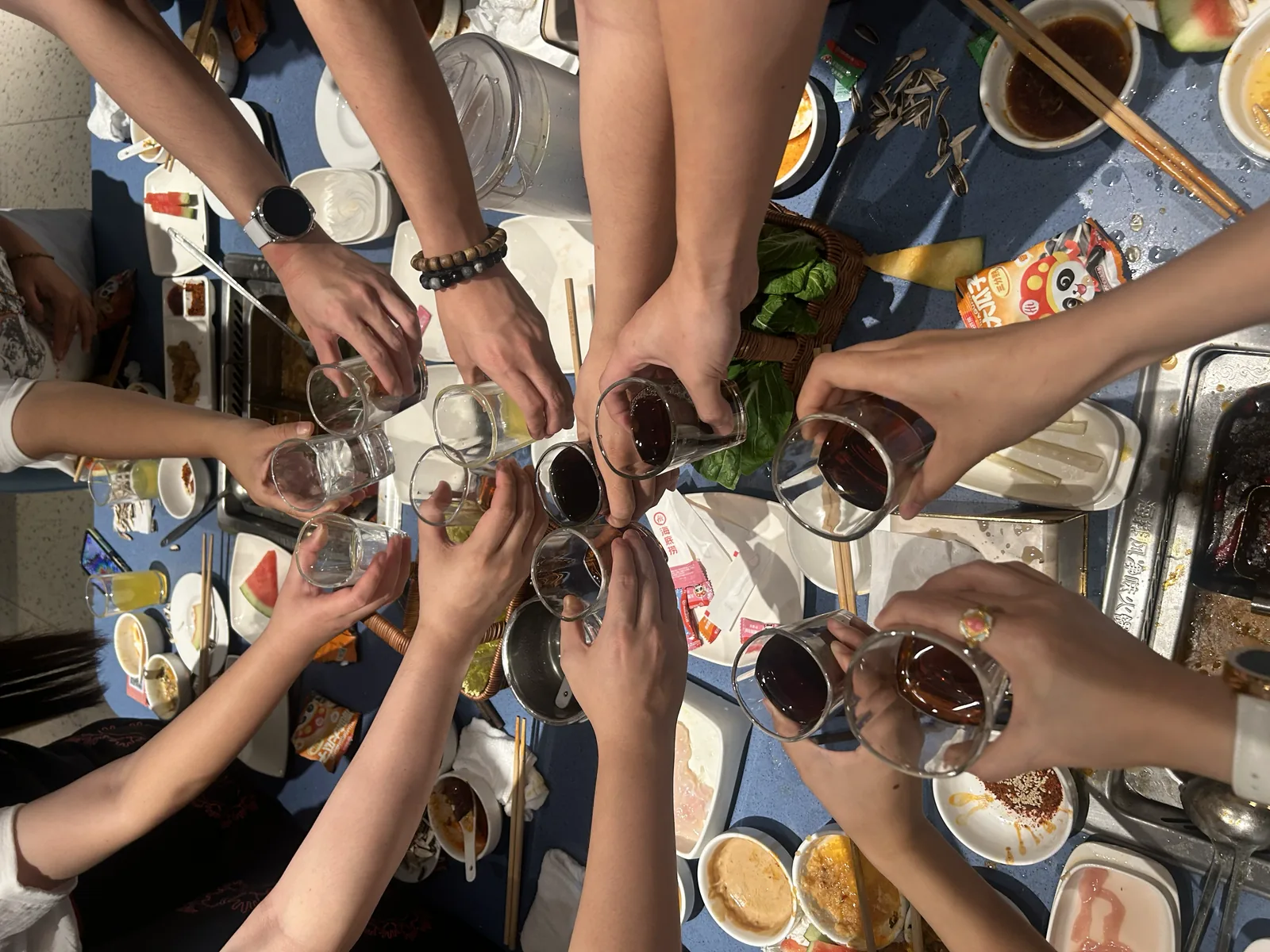 俯拍多人围着桌子举杯
